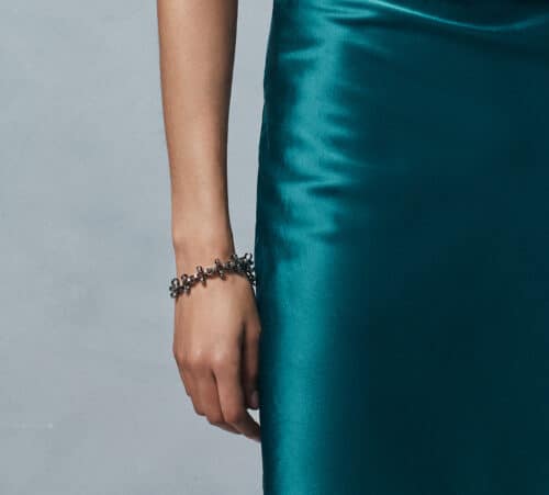 A green silky dress and a silver bracelet