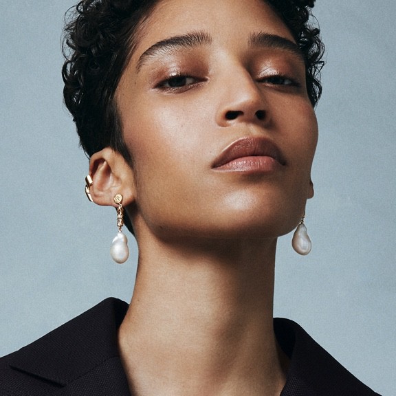 Pearl earrings and a black suit