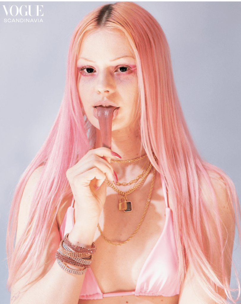 Flicka med rosa hår och guldhalsband